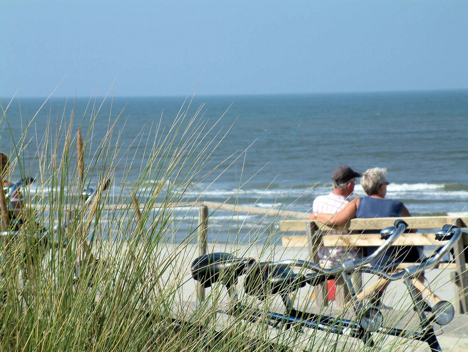 Auf der Bank sitzendes Paar das den Blick auf die Nordsee genießt
